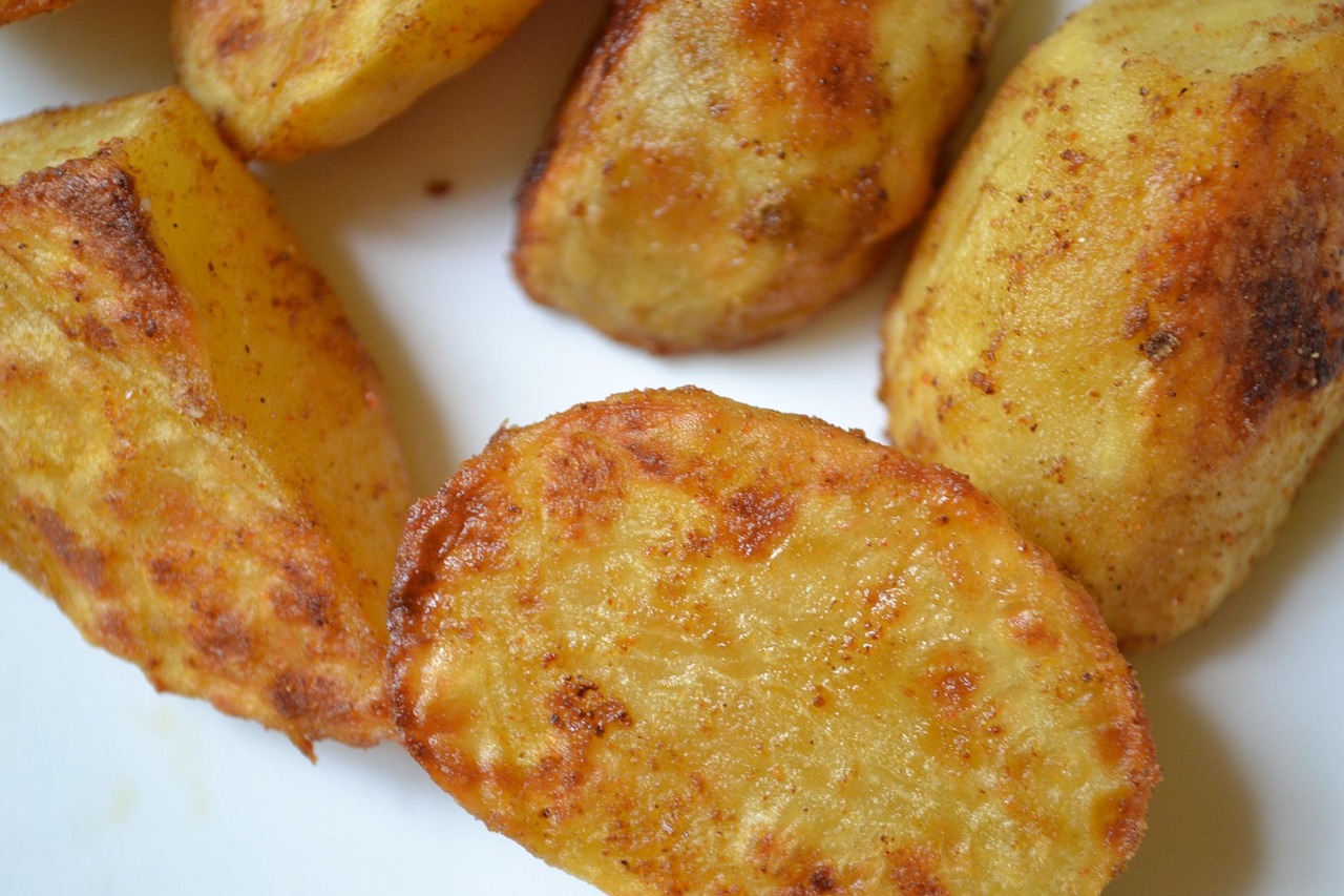 Patate al forno croccanti con spezie, pronte per essere servite in un piatto rustico.